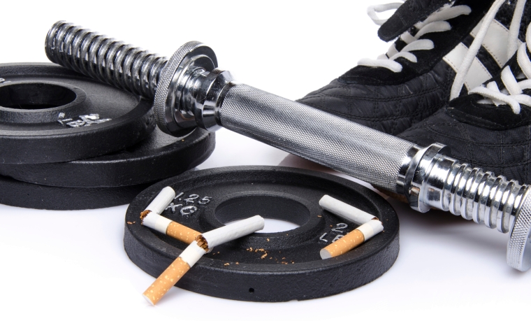 Dumbells, fitness shoes with broken cigarettes
